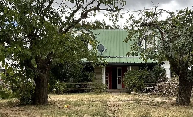 a view of a house with backyard and sitting area