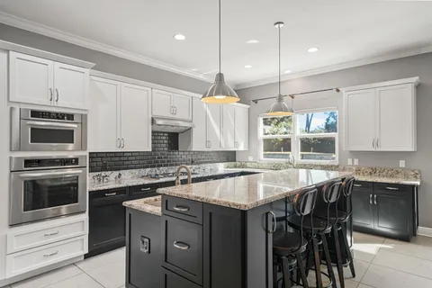 a kitchen with kitchen island a counter space appliances and cabinets