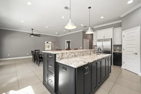 a kitchen with granite countertop a sink a counter space appliances and cabinets