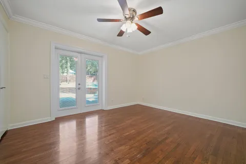 wooden floor in an empty room with a fan