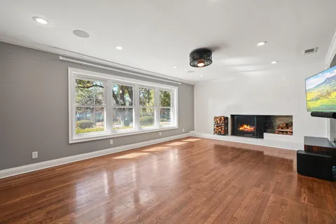 an empty room with wooden floor and fireplace