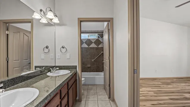 a bathroom with a granite countertop sink a light fixture and a mirror
