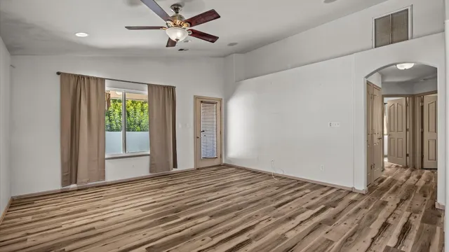 a view of a livingroom with wooden floor and a ceiling fan