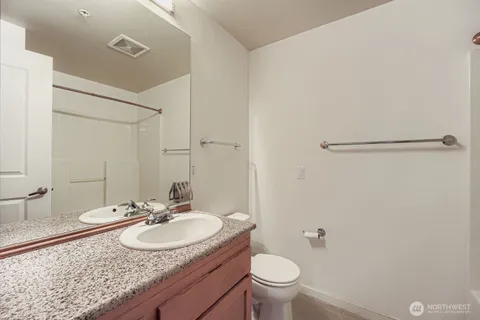 a bathroom with a granite countertop sink and a mirror