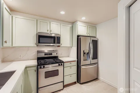 a kitchen with stainless steel appliances white cabinets and a refrigerator