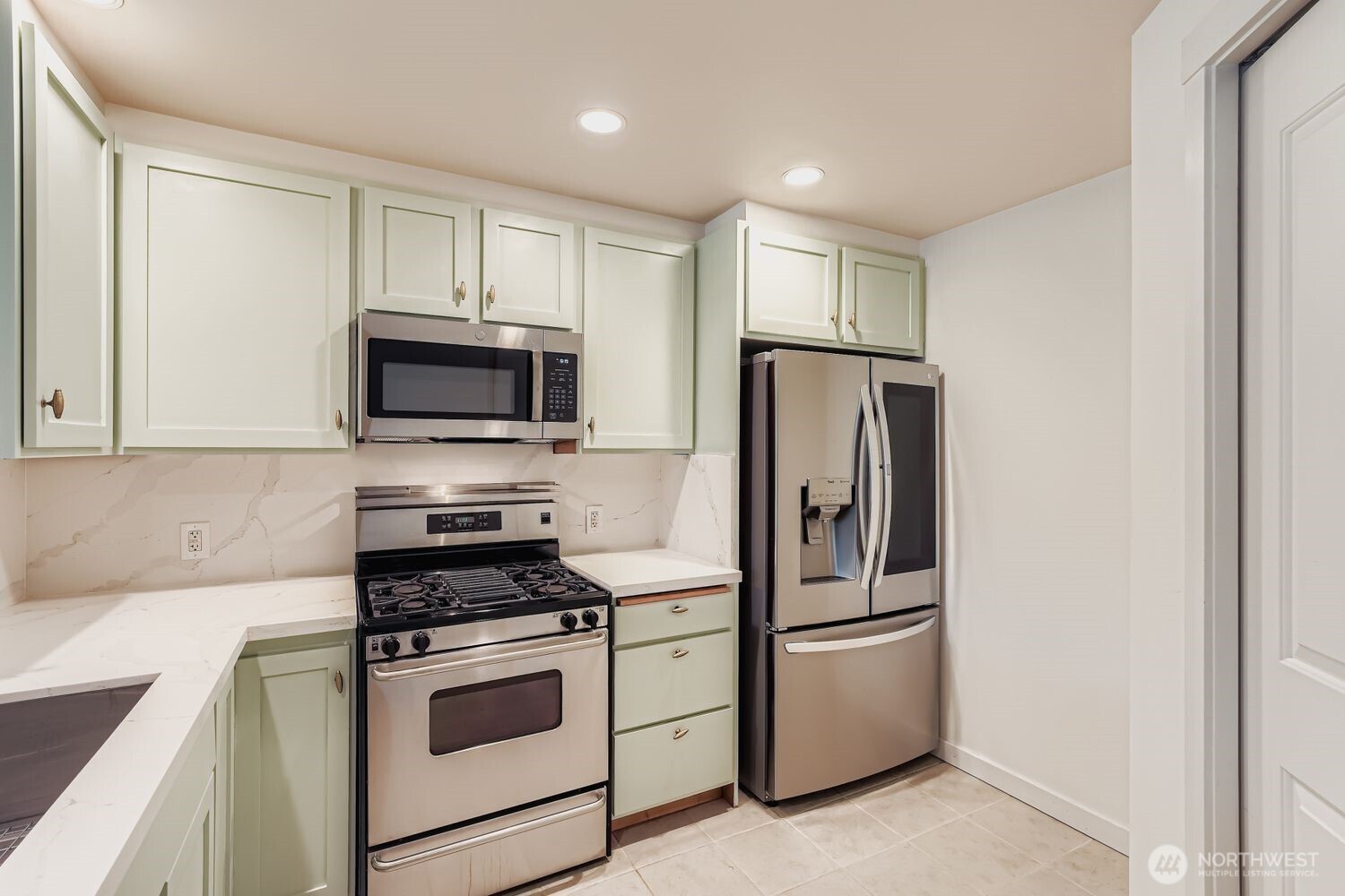 2607 Western Avenue, Unit 612 Seattle, WA 98121 - Photo 6 of 29 a kitchen with stainless steel appliances white cabinets and a refrigerator