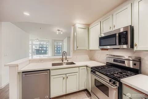 a kitchen with sink stove and microwave