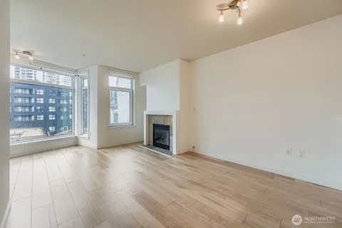 wooden floor fireplace and windows in an empty room