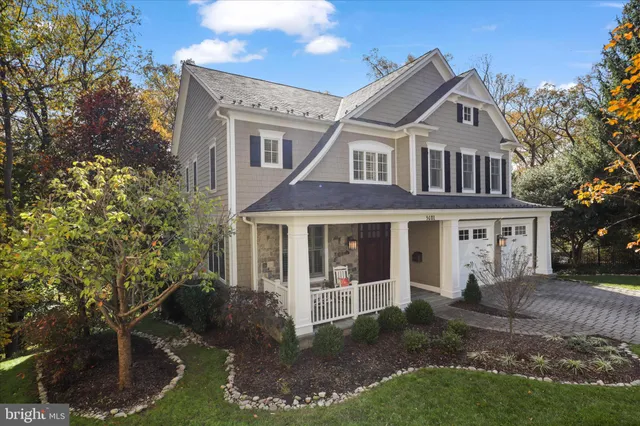 a view of a yard in front of a brick house with large windows
