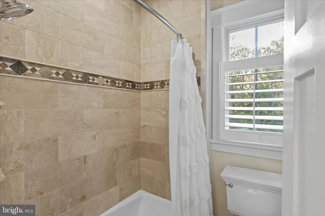 a bathroom with a granite countertop sink toilet and mirror