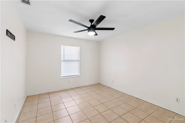 an empty room with windows and fan