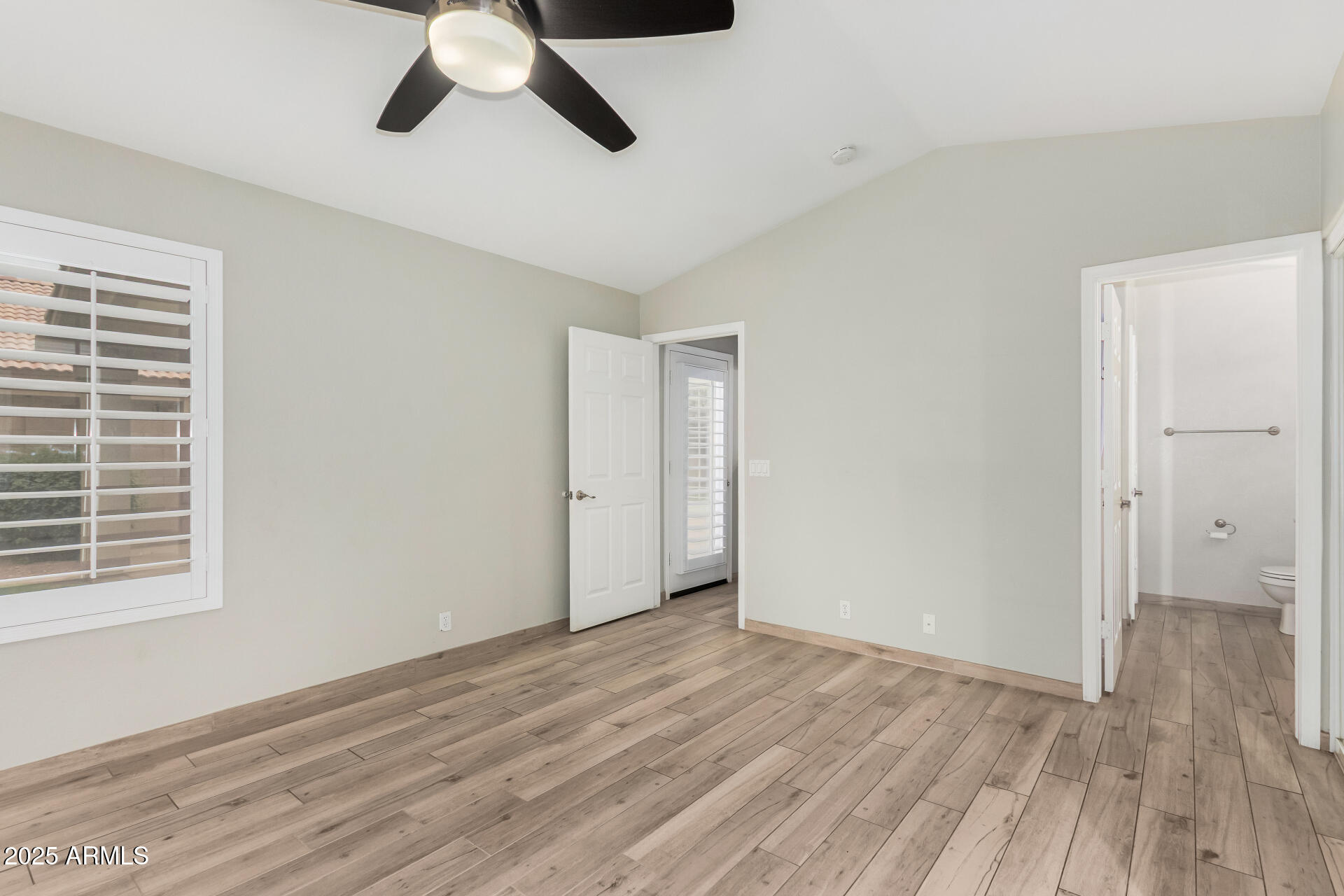 3942 East Agave Road Phoenix, AZ 85044 - Photo 17 of 30 a view of an empty room with wooden floor and a window