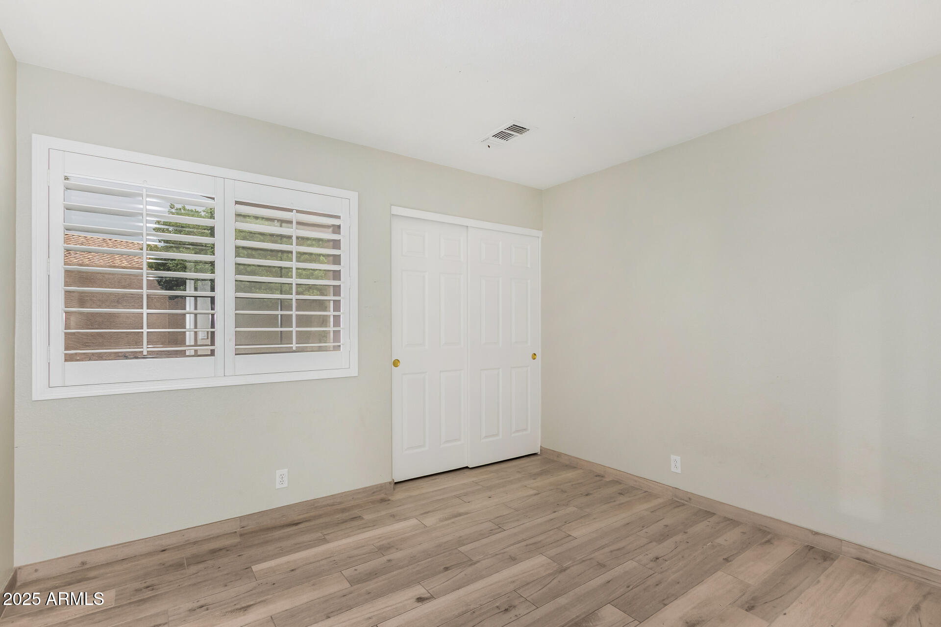 3942 East Agave Road Phoenix, AZ 85044 - Photo 21 of 30 a view of an empty room with wooden floor and windows