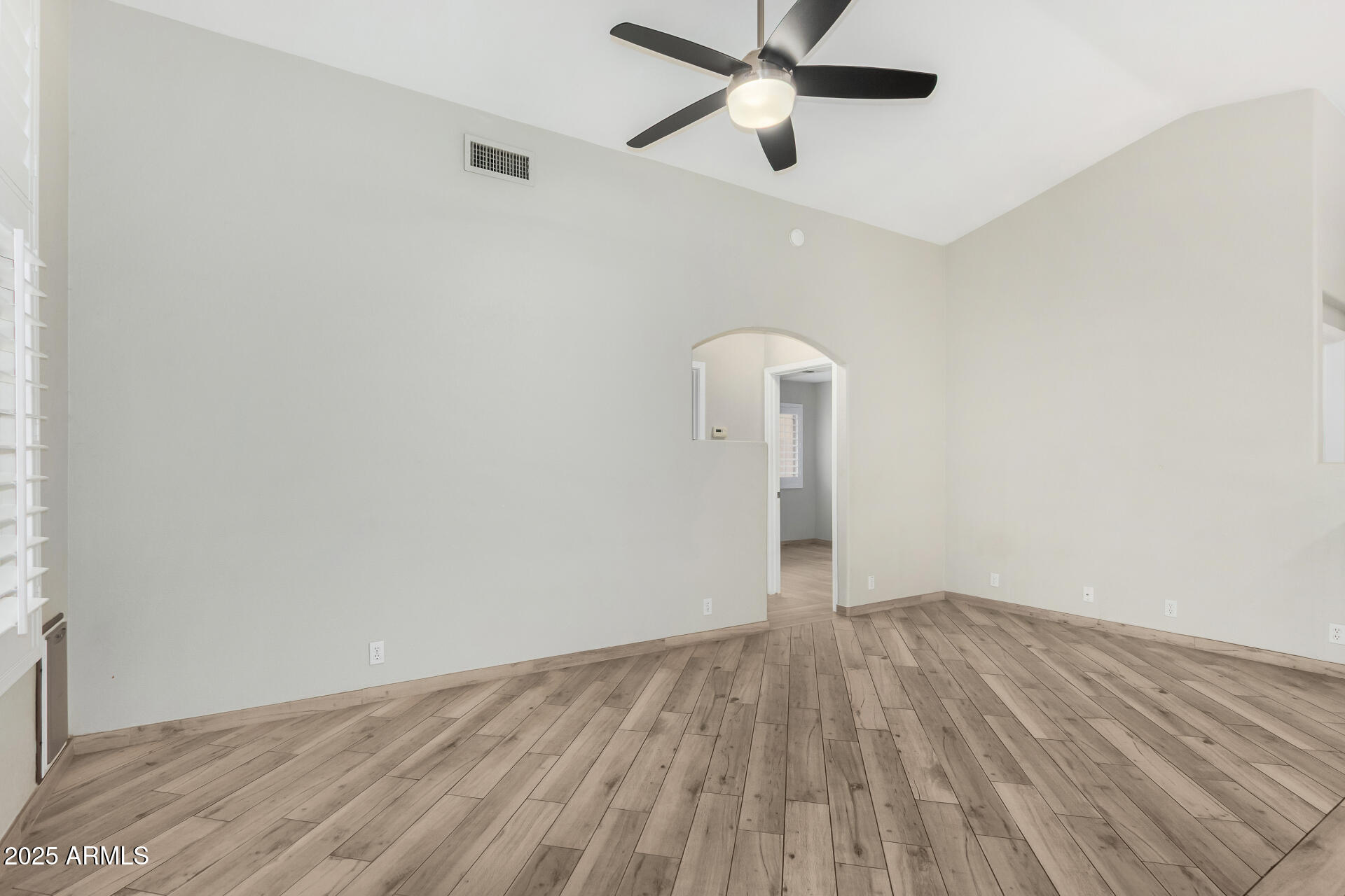 3942 East Agave Road Phoenix, AZ 85044 - Photo 9 of 30 an empty room with wooden floor and windows