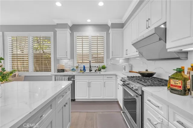a kitchen with stainless steel appliances granite countertop a sink stove and cabinets