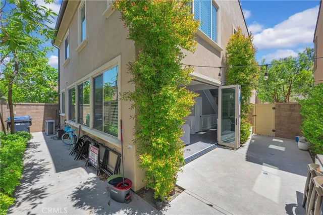a view of a patio with table and chairs potted plants and floor to ceiling window