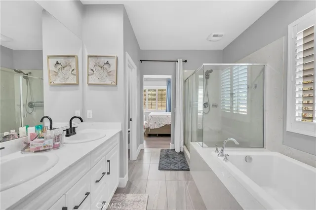 a spacious bathroom with a tub sink and mirror