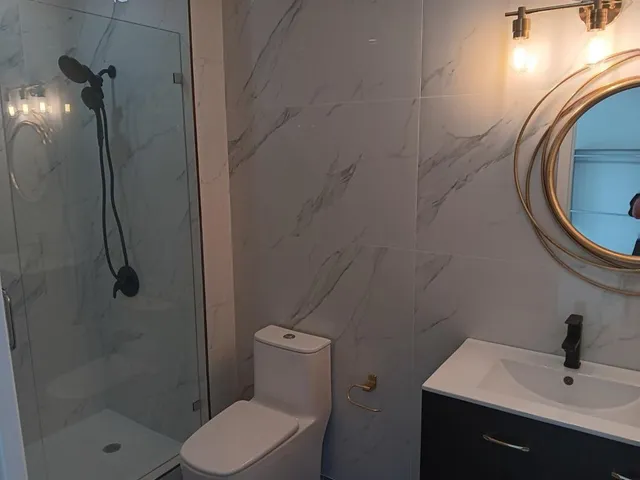a bathroom with a sink a toilet and shower