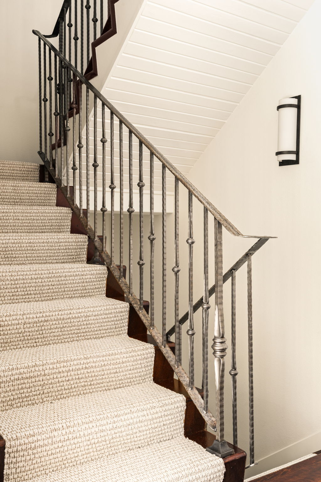 2324 Kinney Road Austin, TX 78704 - Photo 15 of 35 An elegant staircase features custom wrought-iron railings and textured carpeting under a paneled ceiling.