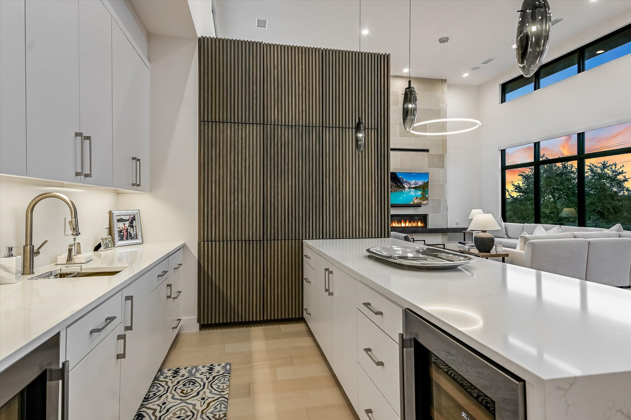 6509 Madrone Tree Lane Austin, TX 78738 - Photo 12 of 40 Kitchen featuring white cabinets, wine cooler, light wood-style floors, decorative light fixtures, and a high ceiling
