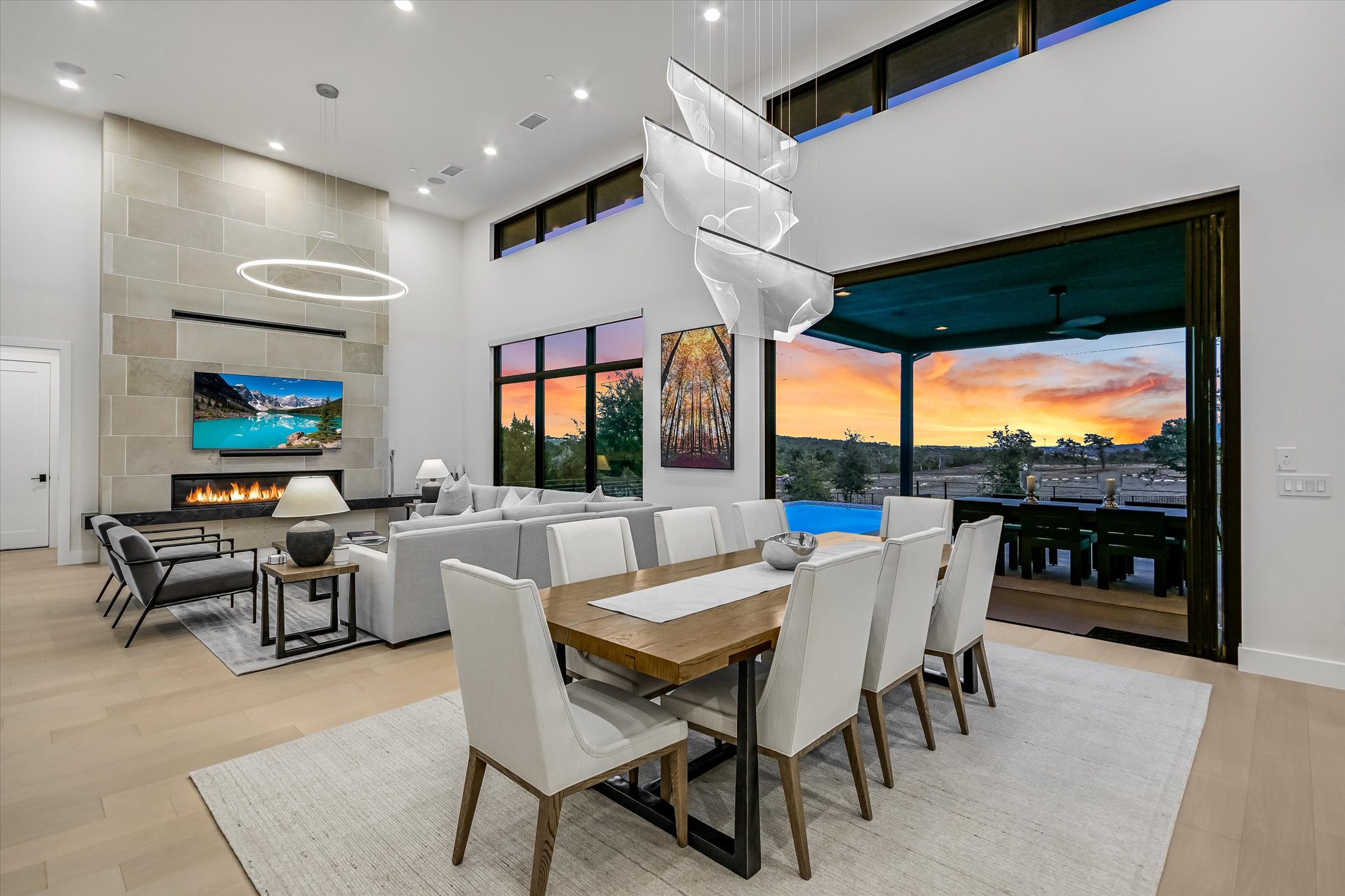 6509 Madrone Tree Lane Austin, TX 78738 - Photo 16 of 40 Dining space featuring a high ceiling, light wood-type flooring, a large fireplace, and recessed lighting