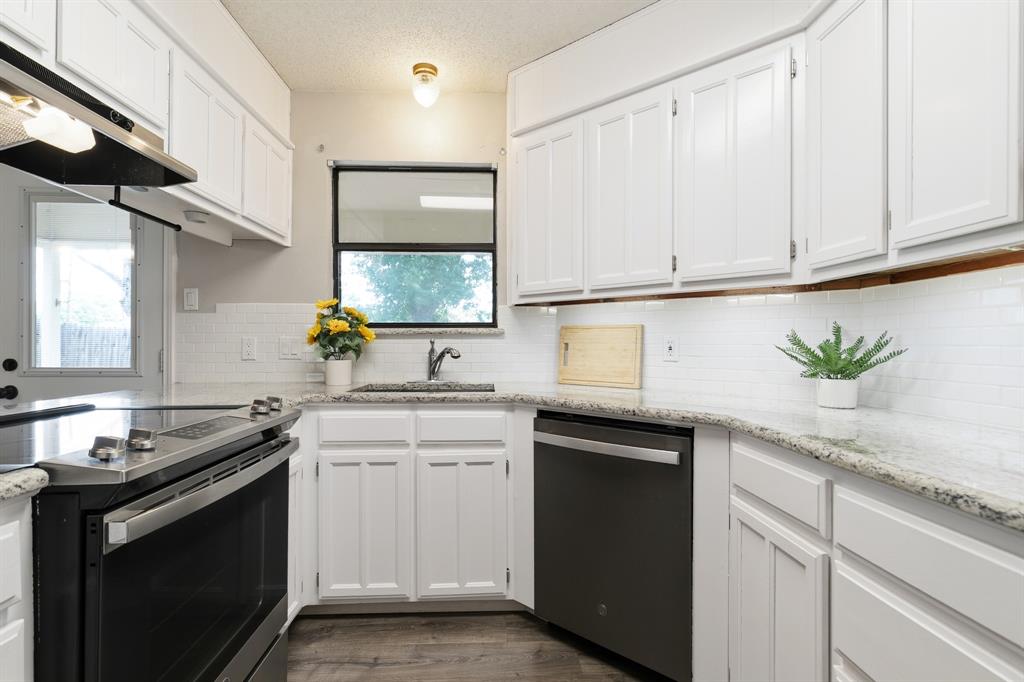 6612 Patsy Lane Watauga, TX 76148 - Photo 12 of 32 Kitchen featuring white cabinetry, light-toned countertops, a white subway tile backsplash, stainless steel appliances, and wood-finish flooring