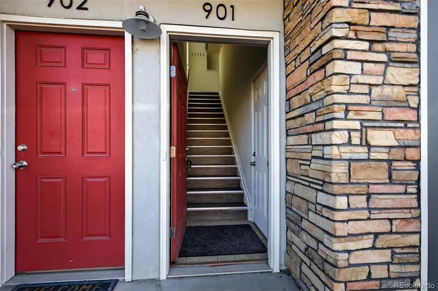 a view of a door with a red door and white walls