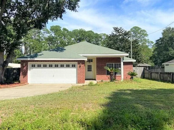 a view of a house with a yard potted plants and a large tree