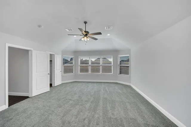 a spacious bedroom with a bed and a chandelier