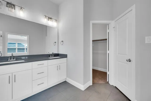 a bathroom with a granite countertop sink a toilet a mirror and bathtub