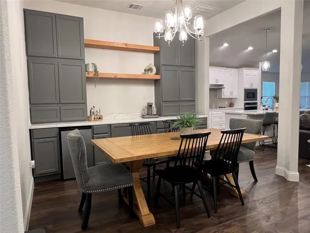 a view of a dining room with furniture a chandelier and wooden floor