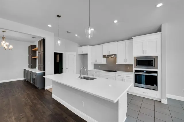 a kitchen with stainless steel appliances kitchen island sink refrigerator and cabinets
