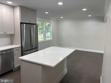 a kitchen with a refrigerator a sink dishwasher and wooden cabinets