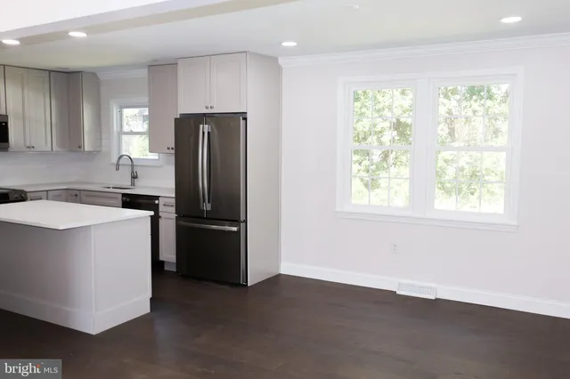 a kitchen with a refrigerator sink and cabinets