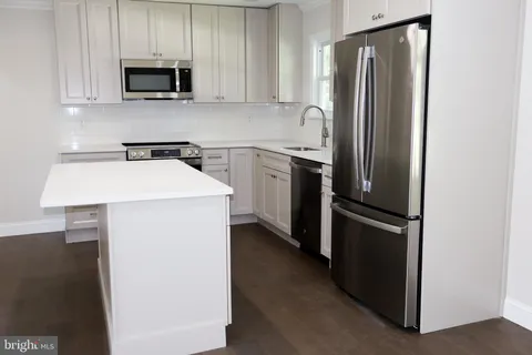 a kitchen with stainless steel appliances a refrigerator sink and microwave