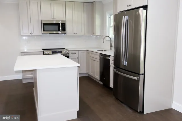 a kitchen with stainless steel appliances a refrigerator sink and microwave