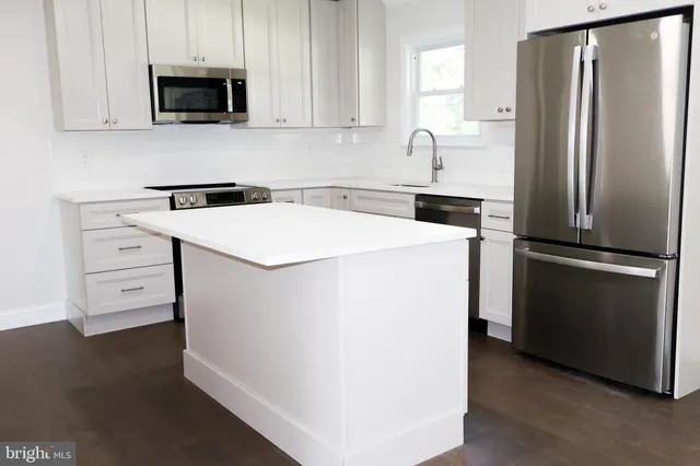 a kitchen with a refrigerator sink and cabinets