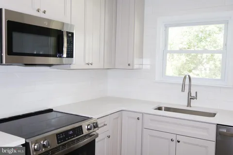 a kitchen with a stove microwave and sink