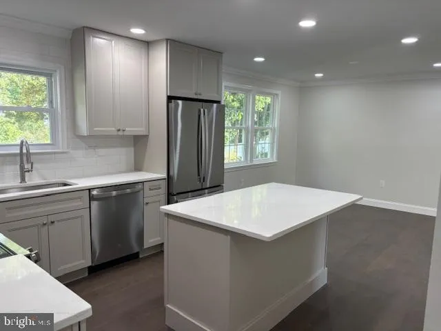 a kitchen that has a sink a window and stainless steel appliances