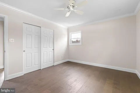 an empty room with a ceiling fan and a window