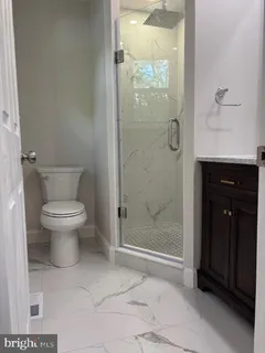 a bathroom with a toilet and a shower