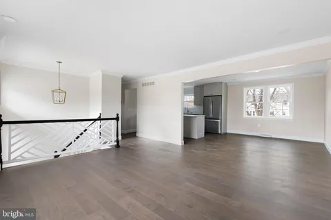 an entryway at an empty room with wooden floor and a window