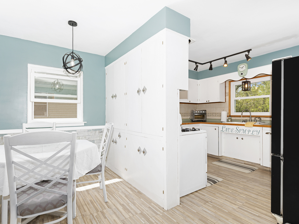 1604 Pine Road Homewood, IL 60430 - Photo 7 of 17 a kitchen with a refrigerator a stove and white cabinets with wooden floor