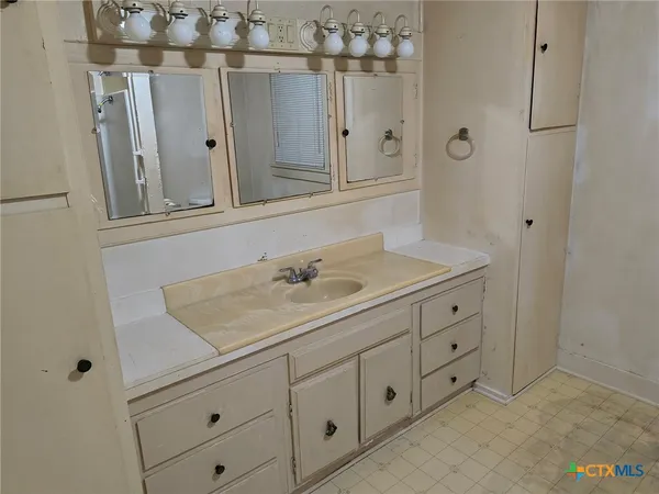a bathroom with a sink vanity and mirror