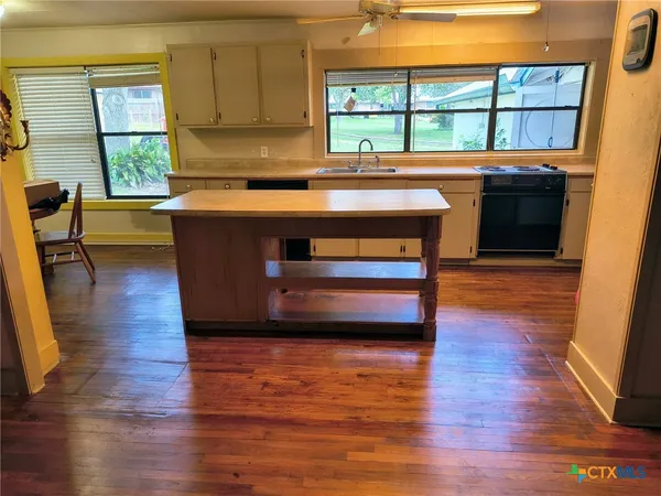 a kitchen with stainless steel appliances granite countertop a stove a sink and a large window