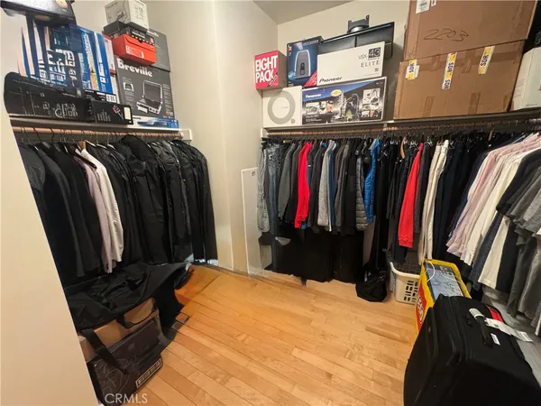 a view of walk in closet with clothes and shoes