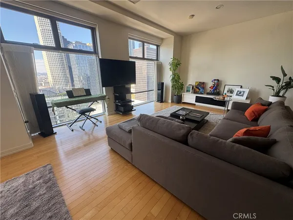 a living room with furniture and a flat screen tv with wooden floor