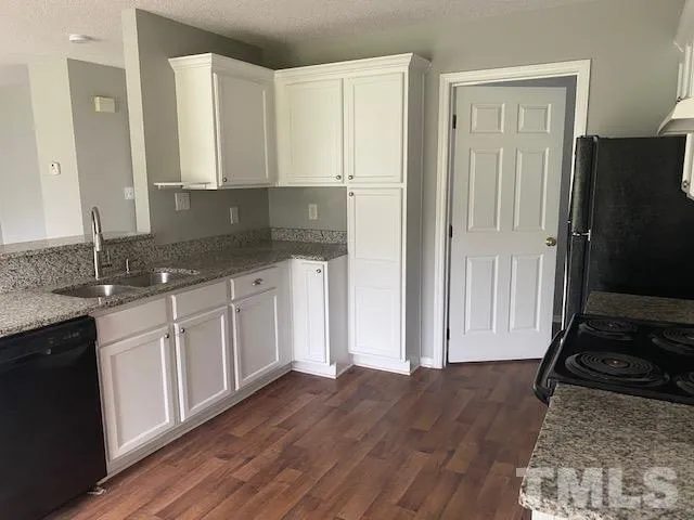 a kitchen with granite countertop a sink and a stove top oven