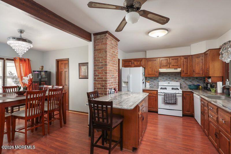 47-49 Appleton Avenue Leonardo, NJ 07737 - Photo 7 of 15 a kitchen with stainless steel appliances granite countertop a stove a refrigerator a kitchen island a dining table and chairs with wooden floor