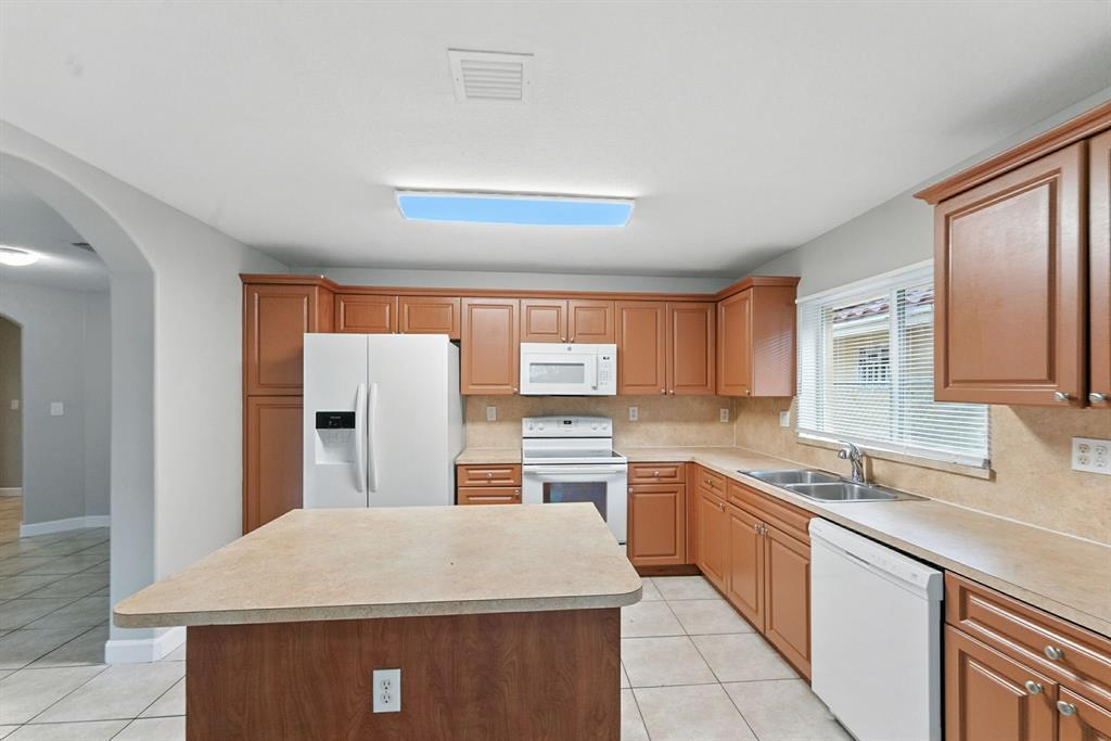 25355 Southwest 135th Court Homestead, FL 33032 - Photo 10 of 40 a kitchen with stainless steel appliances granite countertop a sink dishwasher stove top oven and refrigerator